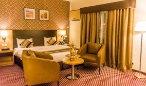 迪拜卡拉马财富酒店的配有一张床和一把椅子的酒店客房