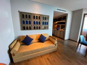 Ấp Thiẹn ÁiApec Mandala Mũi Né - Khách Sạn Nghĩ Dưỡng Luxury Limited的客厅的沙发配有蓝色枕头