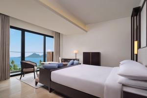 LampungLampung Marriott Resort & Spa的卧室配有一张白色大床和一张书桌
