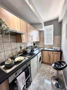 迪拜Dubai Media City Convenient Apartments的厨房配有水槽和炉灶 顶部烤箱