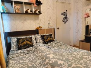 曼谷Friend's House的卧室配有一张带灰色和白色棉被的床