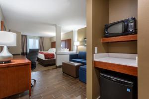 博林格林Comfort Suites的酒店客房带一张床和电视。