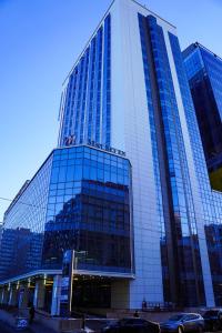 乌兰巴托May Seven Hotel的一座高大的玻璃建筑,上面有标志