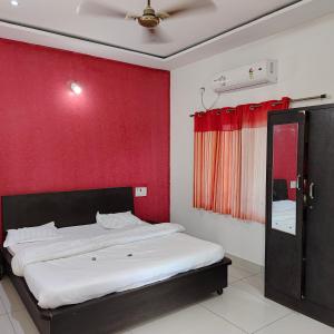 卡希德Vasantam Beach Resort的一间卧室配有一张红色墙壁的床