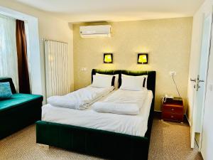 萨拉热窝Halvat Guesthouse的一间卧室配有一张大床和绿色床头板