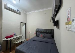 占碑市Steze Guesthouse Syariah Talang Banjar的一间卧室配有一张床和一张桌子