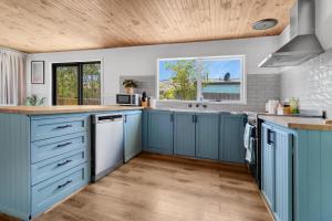 吉朗Recharge in Waurn Ponds的厨房配有蓝色橱柜和木制天花板