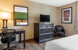拉米拉达Relax Suites Extended Stay - La Mirada的酒店客房设有带书桌和电视的卧室。