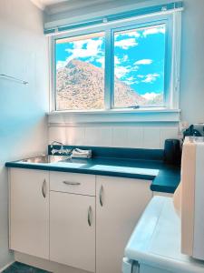 KurowKurow Motel的带水槽的厨房和山景窗户