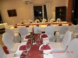 泰克伦堡比斯马克霍恩酒店的一张长桌子,配有白色椅子和酒杯