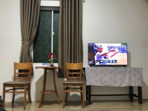 Xóm Chum GăngMộc Lam Homestay的客厅配有电视和2把椅子