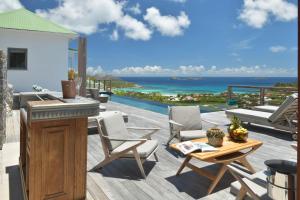 Saint BarthelemyVilla Vogue 5 Bedroom Villa的一个带桌椅的庭院和大海