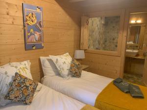 威拉尔-苏-罗伦拉乐纳德木屋酒店的木墙客房的两张床
