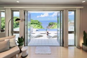 白滨Crystal Besso Shirahama的带沙发的客厅,享有海景