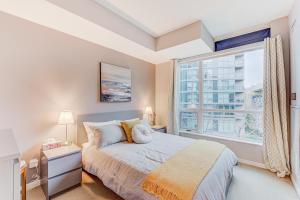 多伦多Prime City Pad 2 Bedroom with CN Tower View的一间卧室设有一张床和一个大窗户