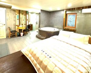 釜山Yeonsan In Hotel的一间卧室设有一张大床和一个浴缸