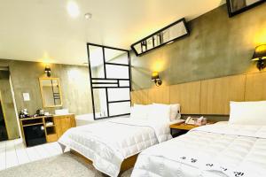 釜山Yeonsan In Hotel的酒店客房,设有两张床和镜子