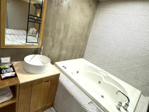 釜山Yeonsan In Hotel的带浴缸和盥洗盆的浴室