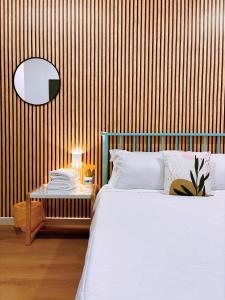 斗湖Muji Homestay Ria Heights Tawau的卧室配有白色的床和木墙