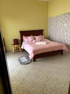 卡巴莱Dangotte Residence Lounge的一间卧室配有一张带粉色床单和一张桌子的床。