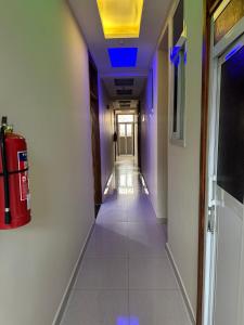 阿鲁沙Aves Executive Hotel的拥有蓝色天花板的走廊和带灭火器的走廊
