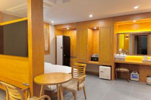 束草市Sokcho Mir Hotel的客房设有桌子和带冰箱的厨房
