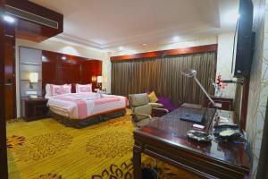 古尔冈SkyCity Hotel Gurgaon的配有一张床和一张书桌的酒店客房