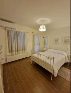 普拉特斯Butterfly Home的白色卧室配有一张床和一个吊灯