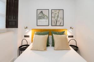 格拉纳达Granadi Apartamentos的卧室配有白色的床和2个枕头