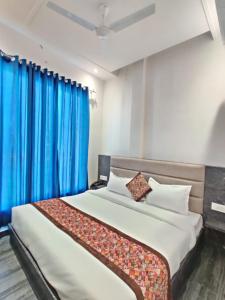 阿姆利则Hotel The Restu And Restaurant 300 Meter From Golden Temple的一间卧室配有一张带蓝色窗帘的大床