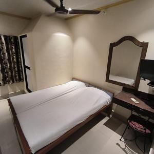 孟买Hotel Rupali的一间小卧室,配有一张床和镜子