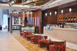 迪拜Marriott Executive Apartments Al Jaddaf, Dubai的一间带桌椅的餐厅和一间酒吧