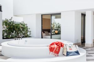 伊维萨镇El Hotel Pacha的浴室设有白色浴缸,配有购物袋