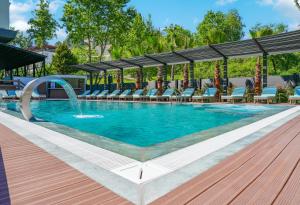 埃利特温泉Vital Thermal Hotel & SPA的一个带椅子的游泳池以及一个喷泉