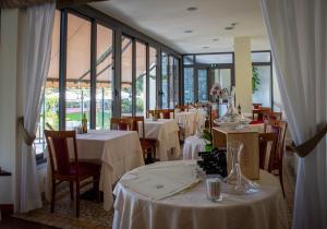 迪亚诺马里纳Hotel Eden Park的餐厅配有桌椅和白色桌布