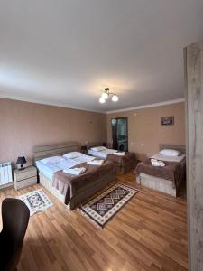 卡兹贝吉Kazbegi Guide的铺有木地板的客房内的三张床