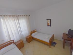 地拉那Vila 57 HOTEL的小房间设有一张床和一张书桌