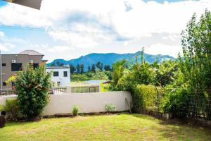 南迪Fijian Homestay - 3 bedroom house的花园设有围栏,部分植物和山脉