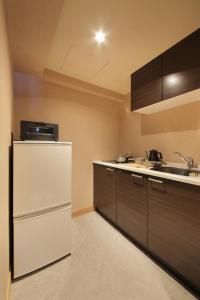 札幌UNWIND Hotel & Bar Sapporo的厨房配有白色冰箱和水槽