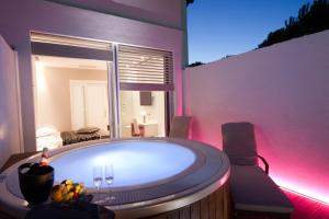 圣克莱门特拉佩斯卡夏乡村酒店的带浴缸的粉红色照明客房