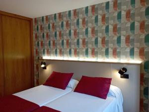 桑亨霍Apartamentos VIDA Sanxenxo的两张位于酒店客房的床铺,配有红色枕头