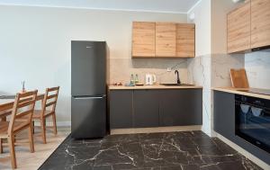 波兹南Poznań Airport Comfort Apartment的厨房配有黑色冰箱和桌子