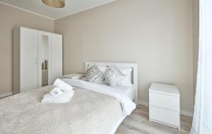 波兹南Poznań Airport Comfort Apartment的白色卧室配有一张带白色床单和枕头的大床