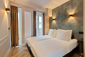 阿姆斯特丹Midtown Hotel Triple Room的一间卧室配有一张带白色床单的大床