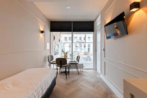 阿姆斯特丹Midtown Hotel Triple Room的客房设有一张床和一张桌子及椅子