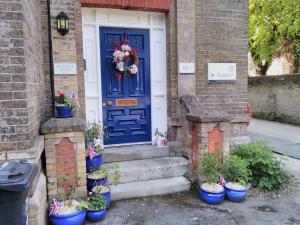 多切斯特The Old Rectory的栽有盆栽植物的房子上的蓝色门
