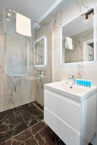 波兹南Poznań Airport Homely Apartment的白色的浴室设有水槽和淋浴。