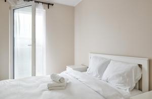 波兹南Poznań Airport Homely Apartment的白色卧室,配有带毛巾的床