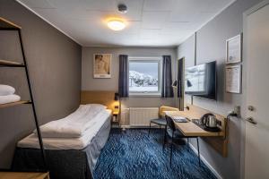 亚西亚特HOTEL SØMA Aasiaat的配有一张床和一张书桌的酒店客房