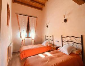 La HorcajadaCasa Rural Lucia的一间卧室设有两张床和窗户。